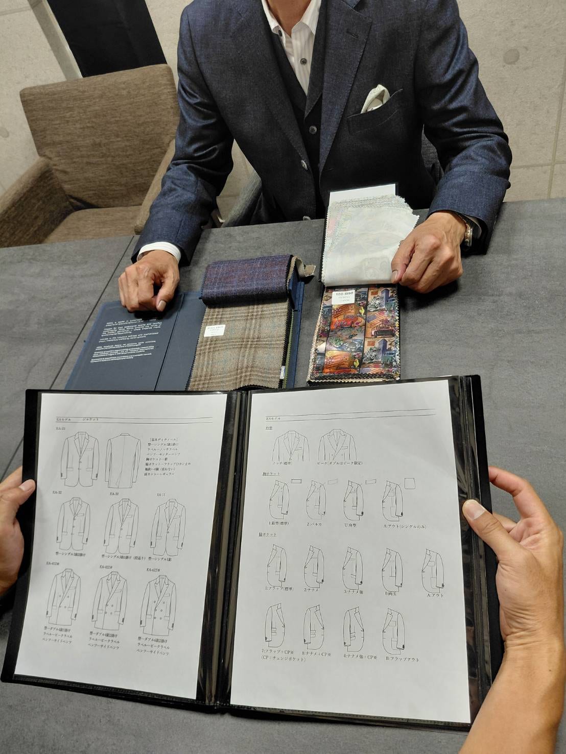 生地サンプルと型見本を前にした出張採寸・ご相談の様子